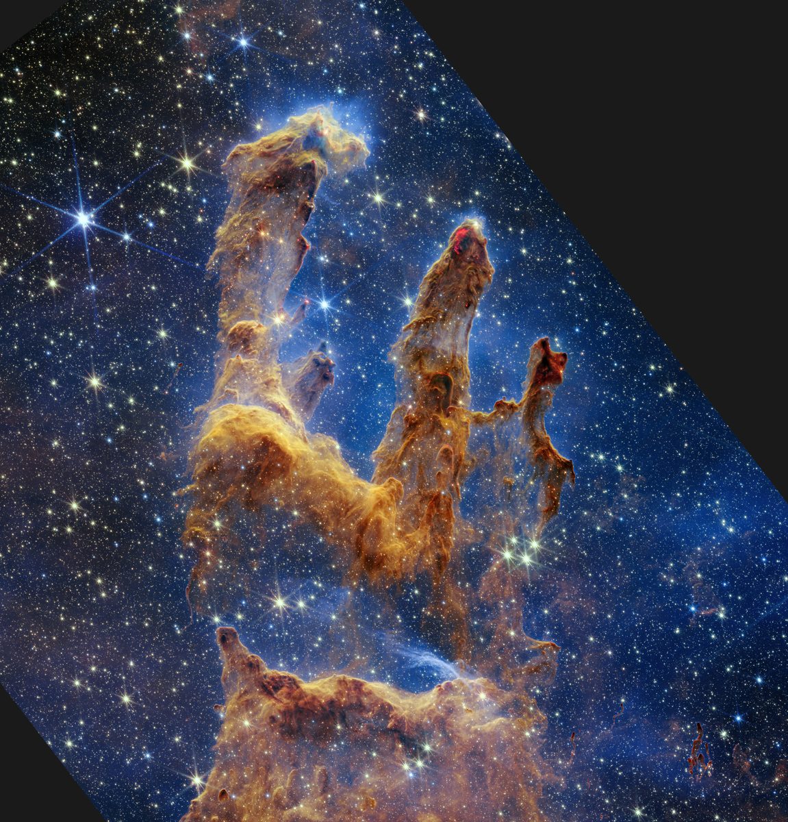 Webb's 2022 near-infrared image of the same pillars, with many newly formed red stars visible inside and around the dust.